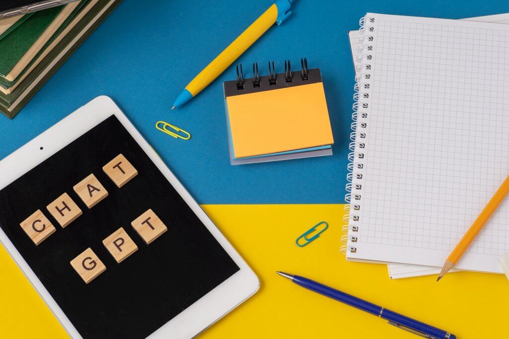 Work and study with the help of a chat bot. Words in wooden letters. Work table with open notebook.